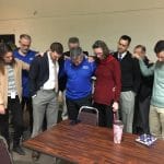 Faculty and staff joined Dave Bechler in prayer when he announced he would be retiring.
