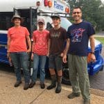 Paul Leaman, head of school (right), joins several students for a service day at a local farm. 