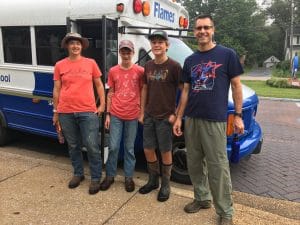 Paul Leaman, head of school (right), joins several students for a service day at a local farm. 