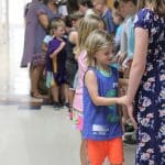 Graduates greet their classmates and teachers with a handshake