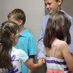 Graduates greet their classmates and teachers with a handshake