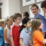 Graduates greet their classmates and teachers with a handshake