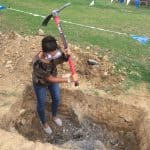 Middle school science classes help install tires in playground.