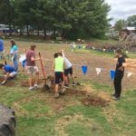 Middle school science classes help install tires in playground.