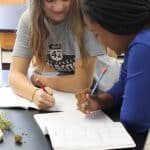 Eighth grade students measuring volume and weight of materials gathered in the playground.