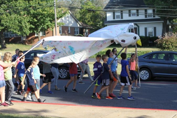 Fifth graders lead the 2019 Peace Parade with a dove puppet the school has used for 15 years.