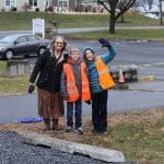 Mrs. Archer and fifth grade traffic helpers greet people in the new drop off loop