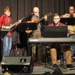 Wes Shuttleworth (seated, at keyboard), music director at UMEI Christian High School, led praise and worship at the Mennonite Educators Conference with fellow music teachers (from left to right) Aaron Johnson, Bethany Christian Schools; Mike Wagner, Hillcrest Academy; Tim Shue, Central Christian School, and Jared Stutzman, Eastern Mennonite School. 
