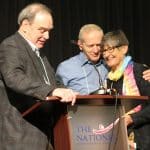 Left to right: Richard Thomas, MEA Chairman of the board, and Conrad Swartzentruber, executive committee chair of Mennonite Schools Council and superintendent of Dock Mennonite Academy, congratulate Elaine Moyer, MEA senior director, on her retirement. 