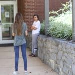 A class takes a break outside for visiting at a distance without face coverings.