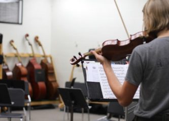 Miriam on violin in strings music room