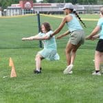 Elementary Field Day with older students setting up and running stations