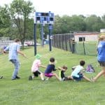 Elementary Field Day with older students setting up and running stations