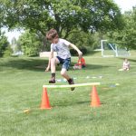 Elementary Field Day with older students setting up and running stations