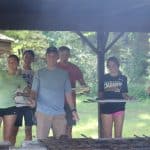 Jesse Blosser facilitates grilling burgers with student volunteers