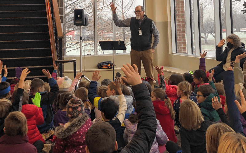EMES students gather in the upper building auditorium foyer to hear guest Dr. Jerry Holsopple discuss his artwork
