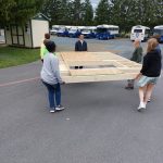 MDS students carry the first wall they constructed for a house in Hurley, Va., to the school parking lot.