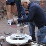 Herb Weaver with raku kiln in EMS courtyard.