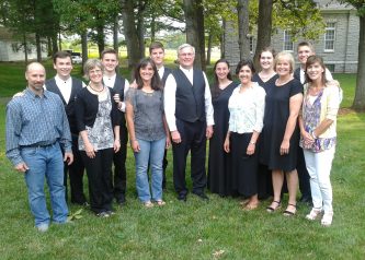 Six EMHS grads were fortunate to sing in Jay Hartzler's first Touring Choir in 1981-82 and see their children sing in his final choir 34 years later. Pictured left to right at the 2015 final Touring Concert concert at Weaver's Mennonite Church