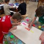 Title: Cozy Fire
Size: 24”x18”
Medium: acrylic paint
Description: 4th grade artists brainstormed and voted on an inspirational saying to serve as the centerpiece of their painting. Next, they collaborated to determine the color scheme and design. This was an important exercise in both sharing and listening respectfully. Students worked in small groups to draw and paint the composition. As the final step in their creative process, the class brainstormed title ideas for their piece then voted for their favorite.
