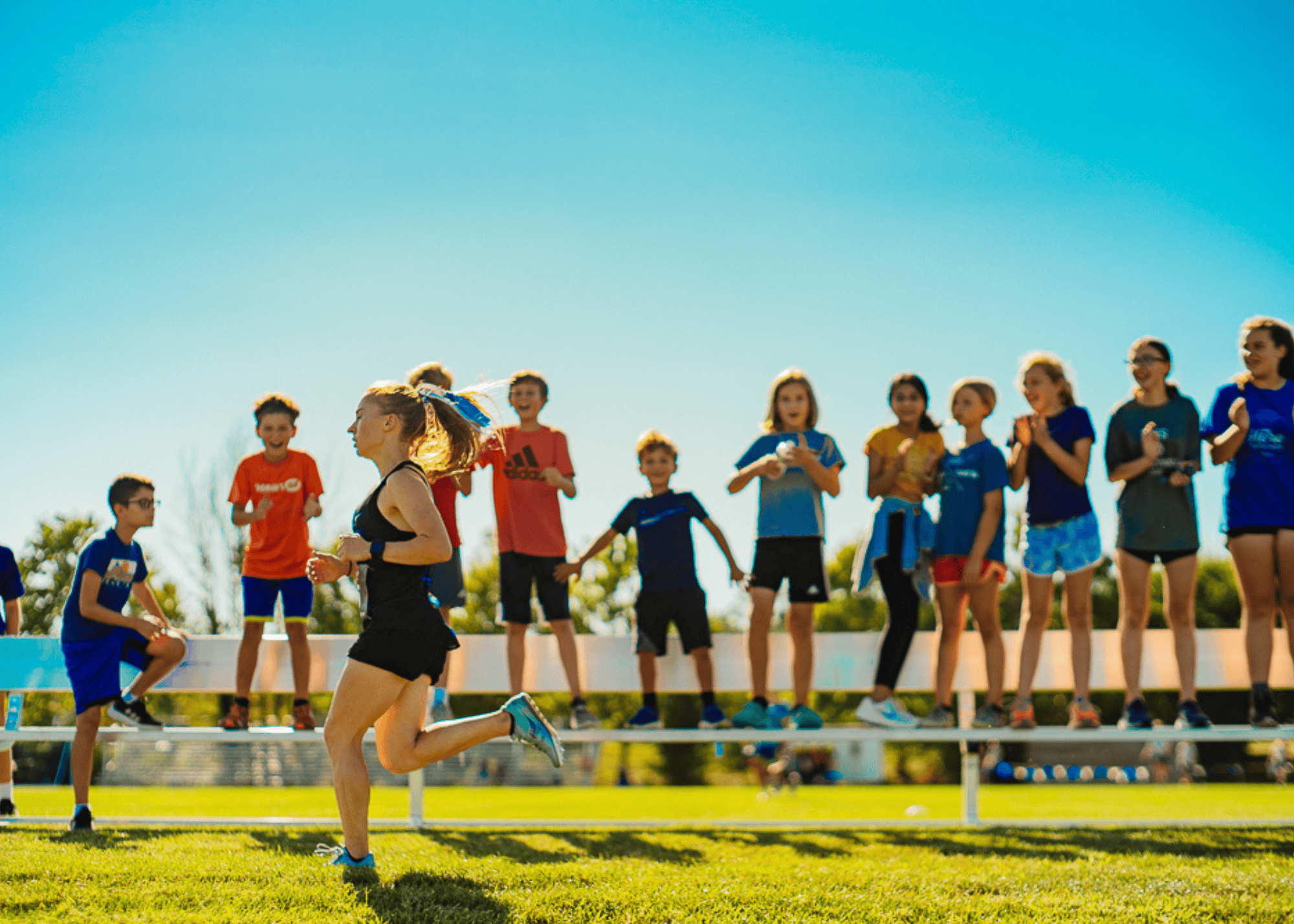 EMES and EMMS students cheer on alum, Erin Loker while running XC